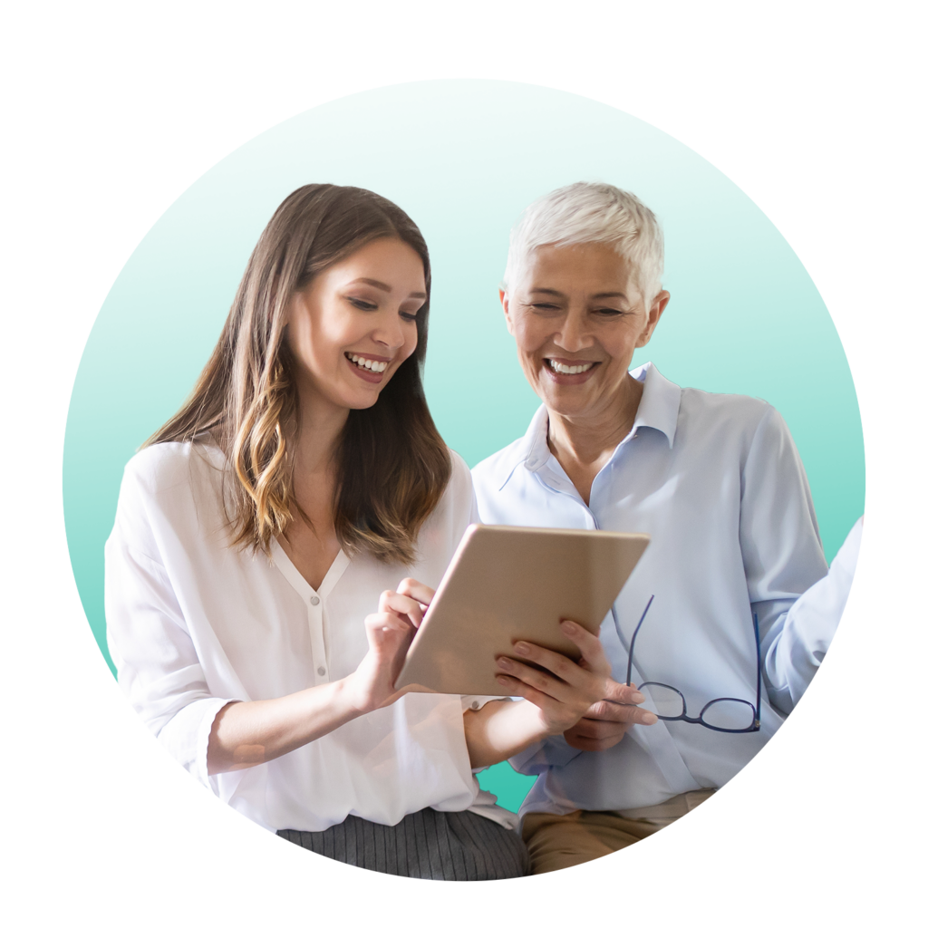 Two HR employees looking at performance management software on tablet.